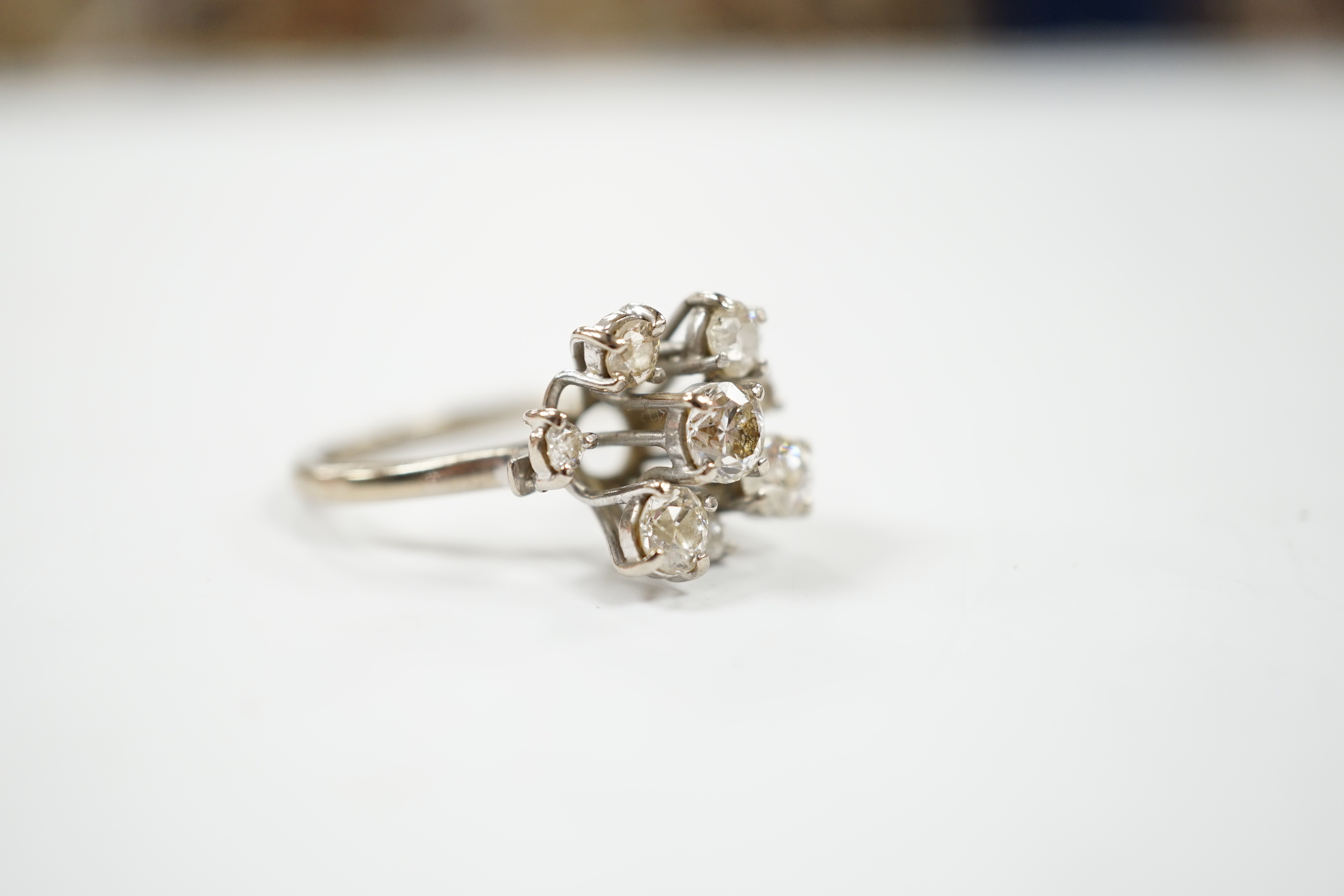 A modern 18ct white gold and graduated eight stone diamond cluster set dress ring, size S, gross weight 7 grams.